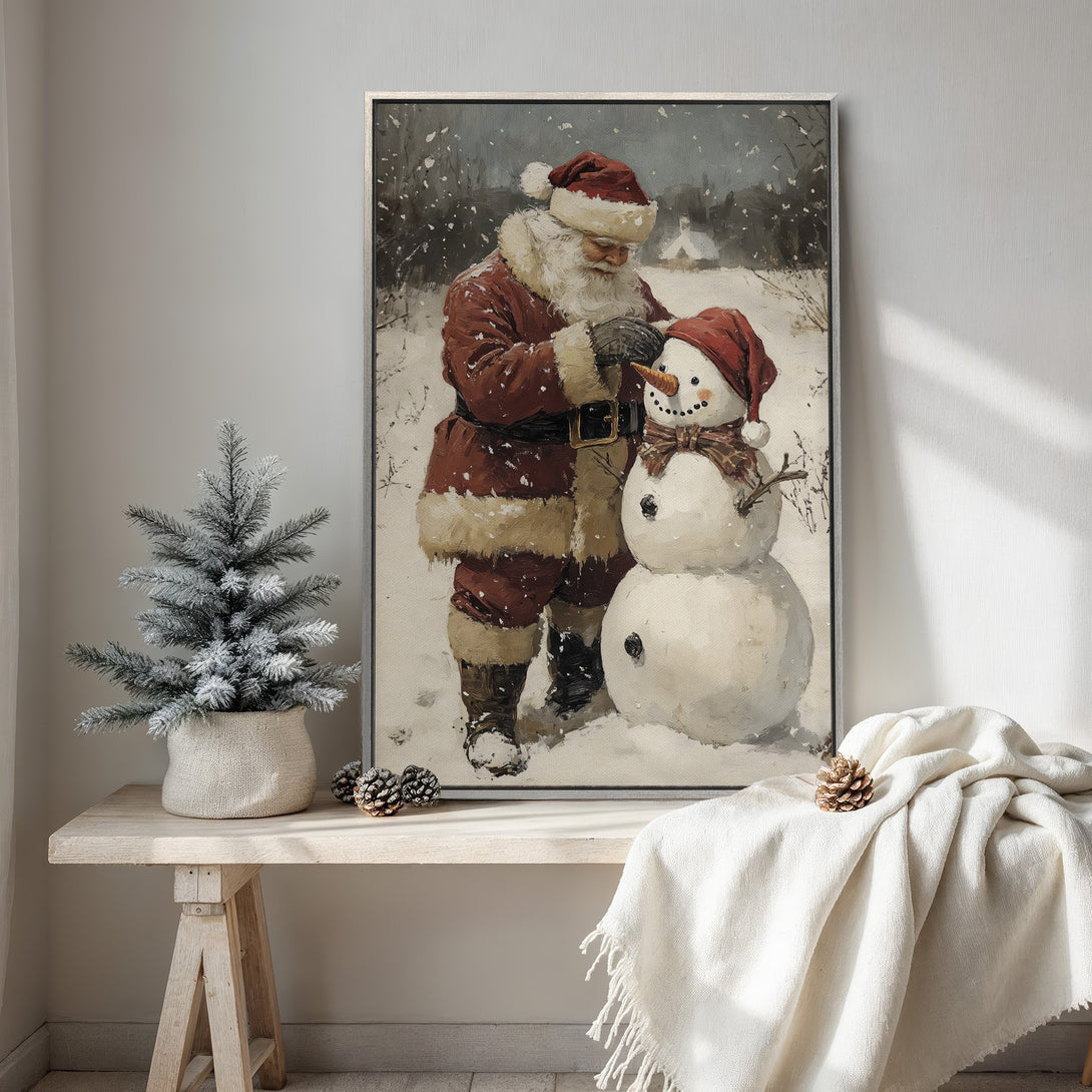 Framed Wall Art: Vintage Christmas scene of Santa building a snowman. Rustic style with warm red and neutral tones, perfect holiday decor.