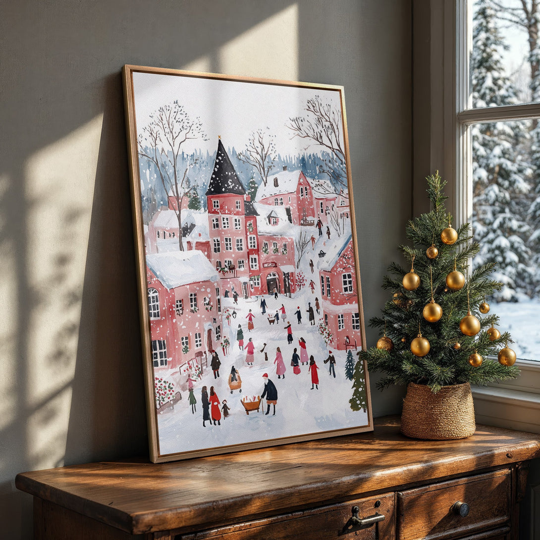 Framed Wall Art featuring a charming winter village scene in a watercolor style. Soft pink and blue color palette, perfect for holiday decor.