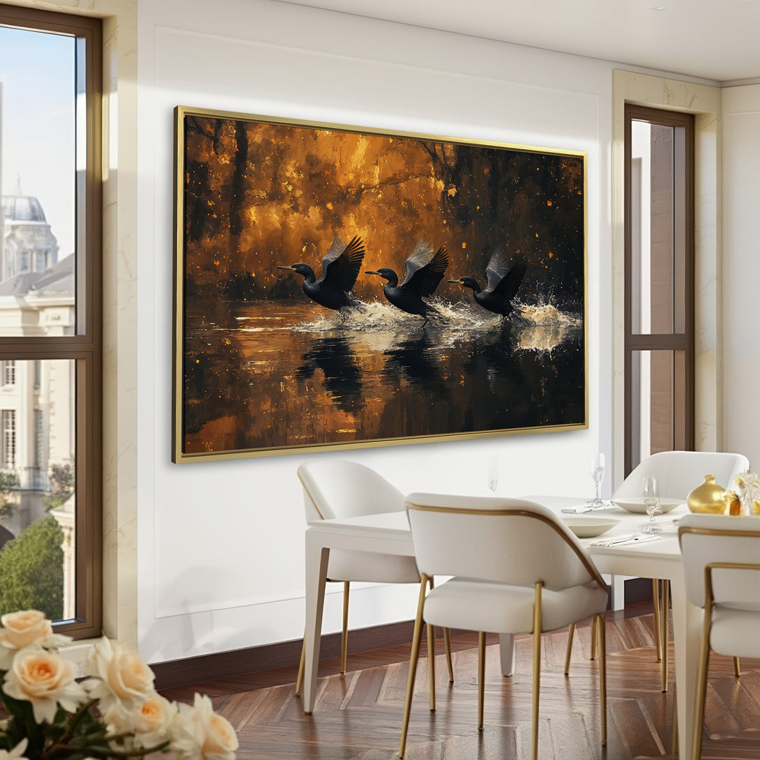 Canvas Print of birds taking flight over water, in a warm gold and black palette, displayed in a stylish interior. Perfect wall art!