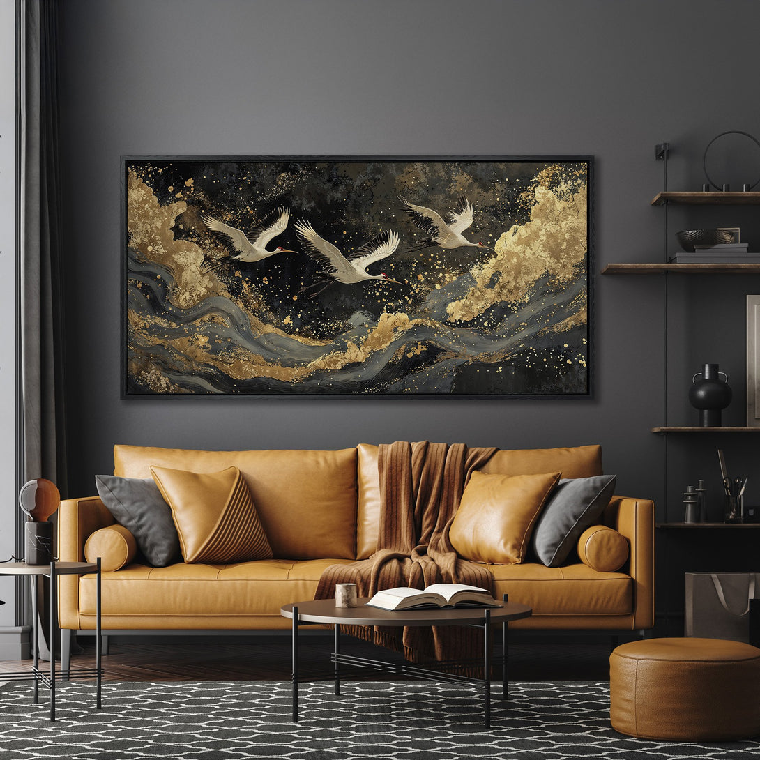 Framed Wall Art featuring elegant cranes in flight. Modern style with a black, gold, and gray color palette. Enhance your living room decor with this stunning piece.
