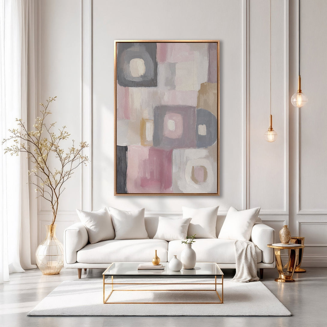 Framed Wall Art featuring an abstract geometric design in soft pink, gray, and neutral tones, displayed in a modern living room setting.