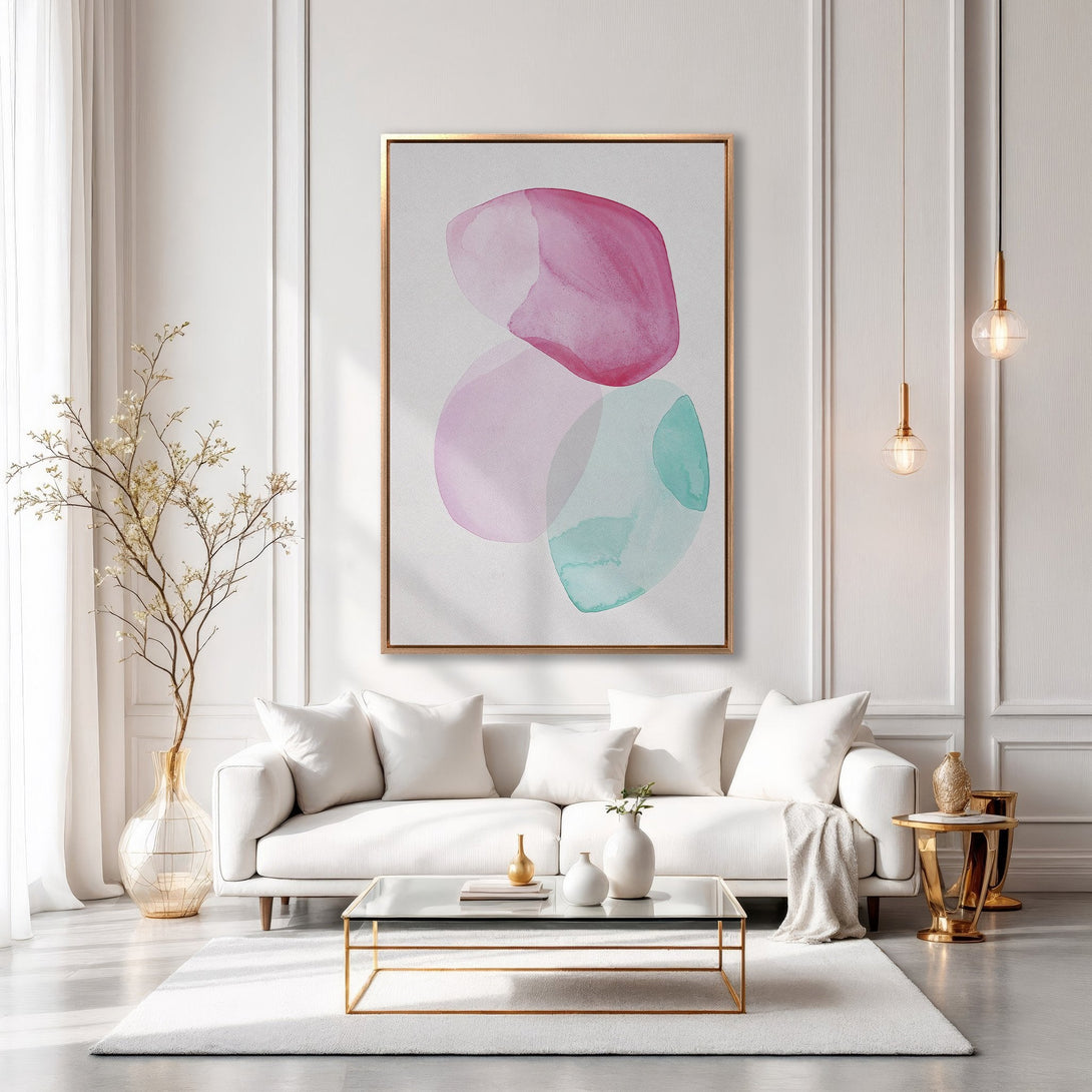 Framed Wall Art: Abstract watercolor canvas print in pink, teal, and lavender. Modern art for living room decor, shown in a stylish interior.