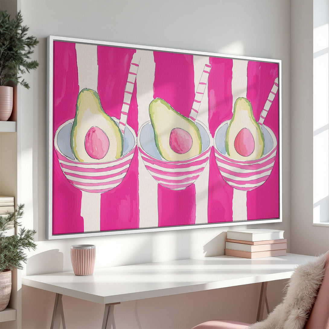 Framed Wall Art featuring a vibrant avocado painting in a modern, watercolor style with a pink and white striped background. Perfect for kitchen decor!