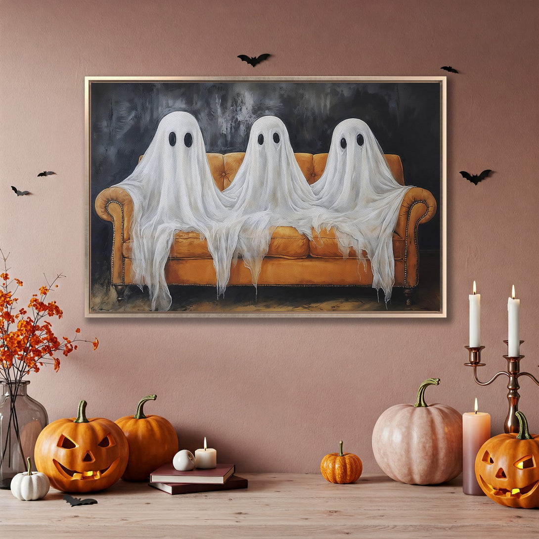 Framed Wall Art: Spooky Halloween artwork of three ghosts on a couch. Neutral color palette with orange accents. Perfect for fall decor!