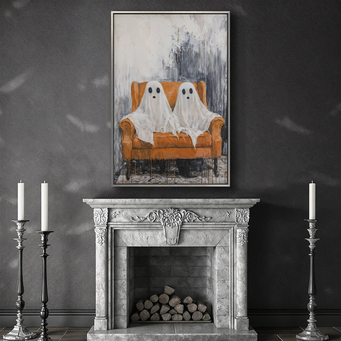 Framed Wall Art featuring two adorable ghost figures on an orange chair. Modern, spooky art in a neutral color palette. Perfect Halloween decor!