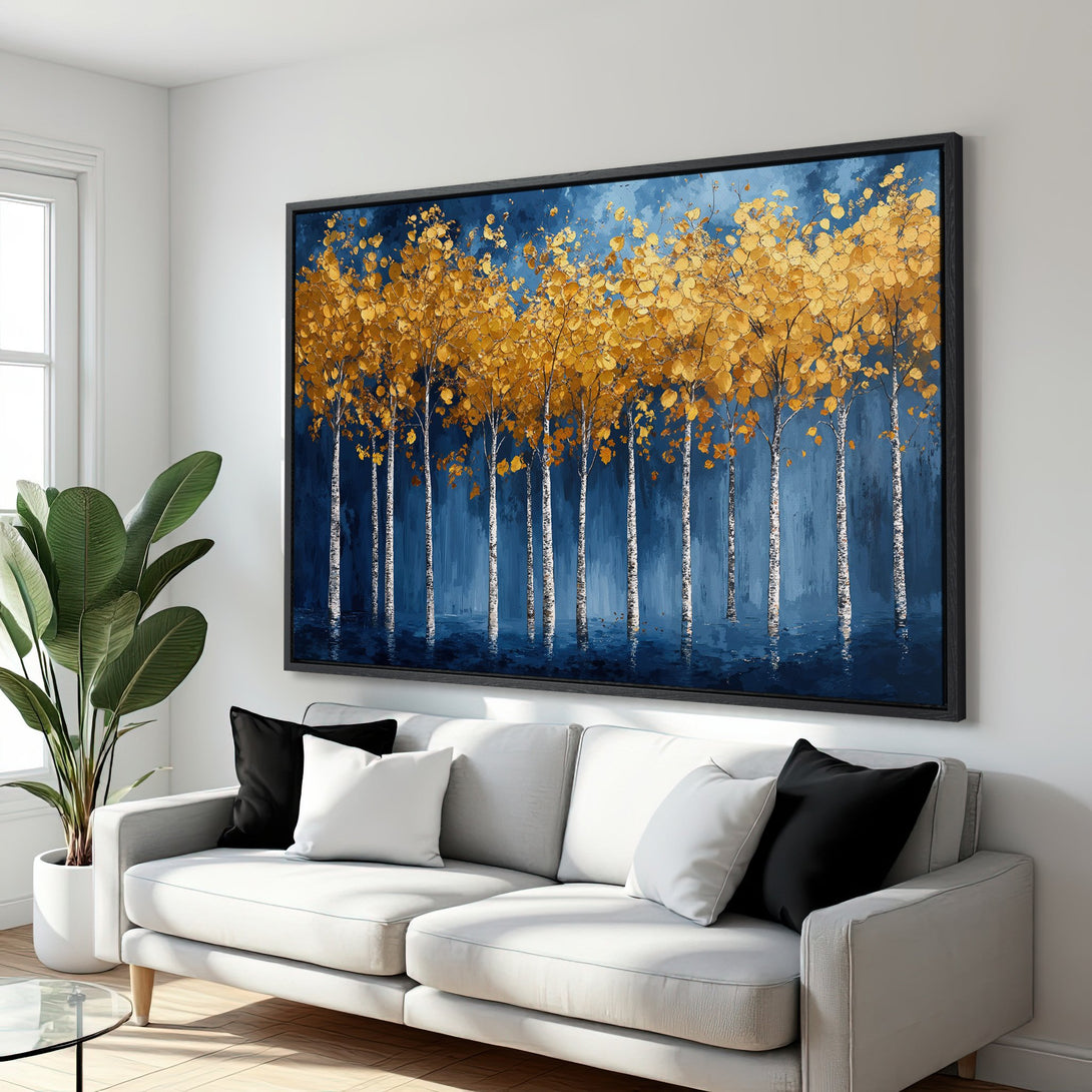 Framed Wall Art featuring a stylized forest scene with gold leaves and blue background. Modern art in a living room setting.