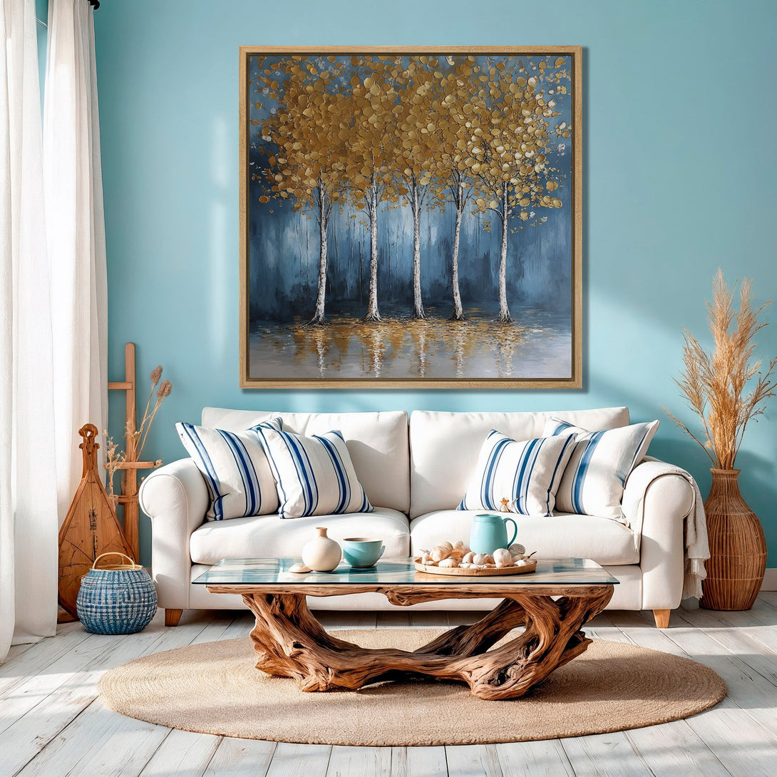 Framed Wall Art: Gold leaf tree painting in a coastal living room. Blue and gold color palette complements the serene, modern interior design.