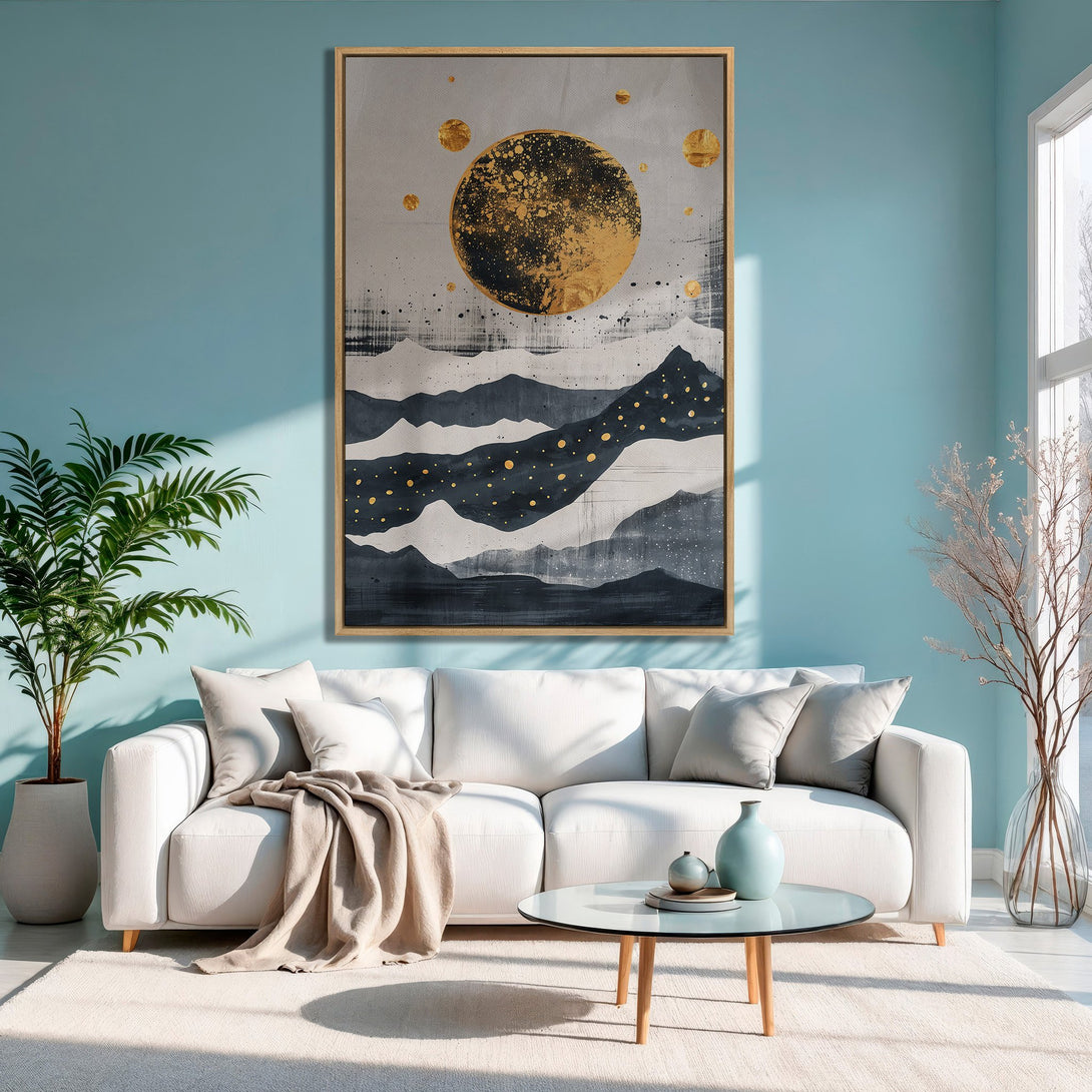Framed Wall Art featuring an abstract mountain and sun design in gold, gray, and navy tones, displayed in a modern living room.