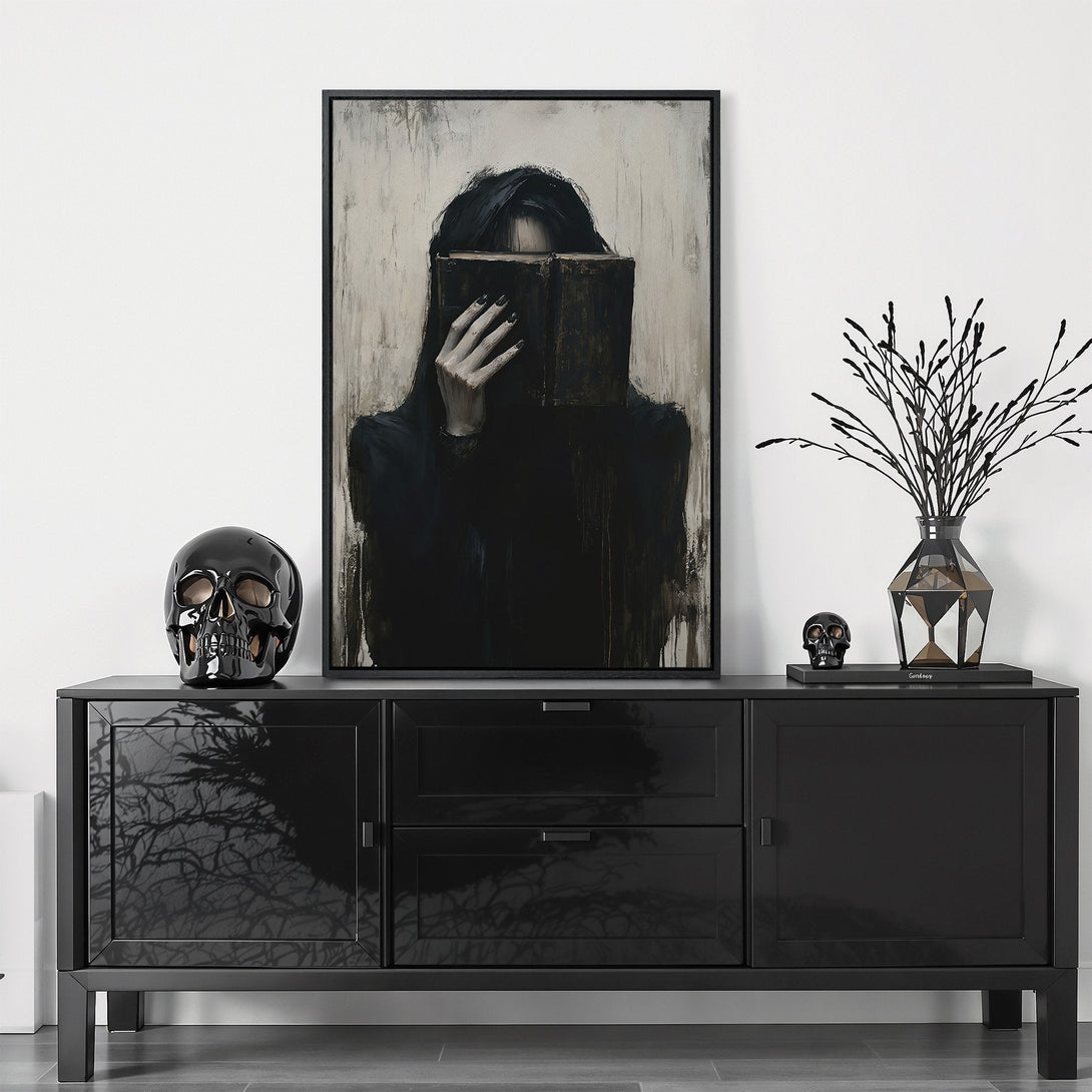 Framed Wall Art featuring a dark, gothic portrait of a woman with a book, in a moody black and neutral palette. Perfect for adding a touch of mystery.