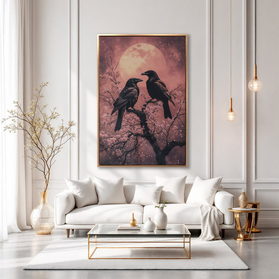 Framed Wall Art: Two ravens perched on a flowering branch against a pink moon. Elegant artwork in a modern living room. Soft pinks, blacks, and golds.