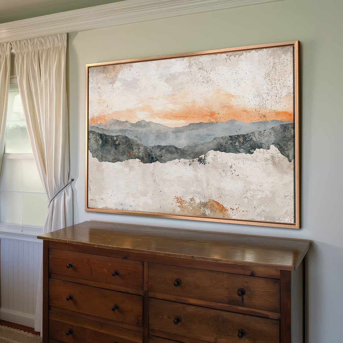 Framed Wall Art featuring an abstract mountain landscape in watercolor style. Earthy tones of orange, gray, and beige create a calming aesthetic.