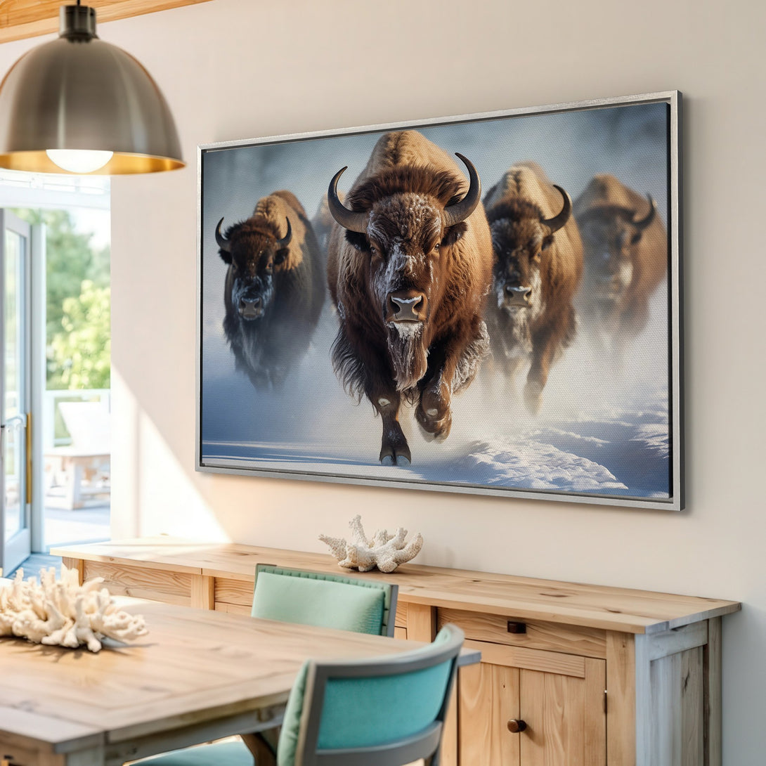 Framed Wall Art featuring a herd of bison running through snow. Earthy tones of brown, white, and blue create a captivating wildlife scene.