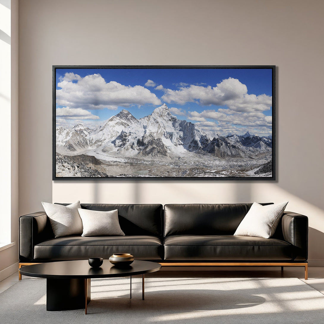 Framed Wall Art: Stunning mountain landscape Canvas Print. Blue sky, white clouds, and snow-capped peaks. Modern interior decor with neutral color palette.