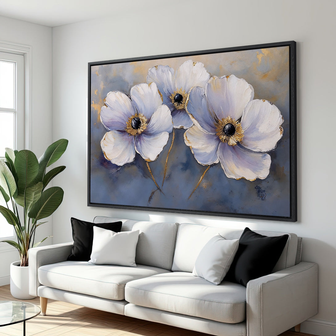 Framed Wall Art: Elegant floral canvas print in a modern living room. Features white flowers with gold accents, blue & gray tones. Perfect home decor.
