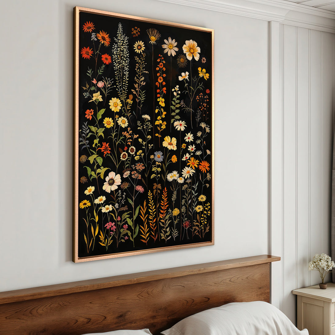 Framed Wall Art featuring a botanical floral design with warm yellow, orange, and red hues on a black background, perfect for bedroom decor.