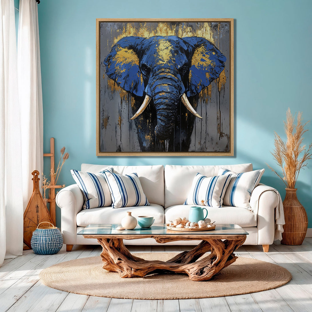 Framed Wall Art: Majestic elephant painting in blue and gold tones, displayed in a stylish living room. Enhance your decor with this stunning canvas print!
