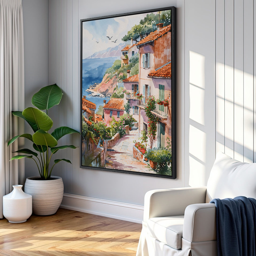 Framed Wall Art featuring a watercolor coastal scene. Warm color palette with terracotta roofs, blue sea, and lush greenery. Perfect for adding a touch of serenity.
