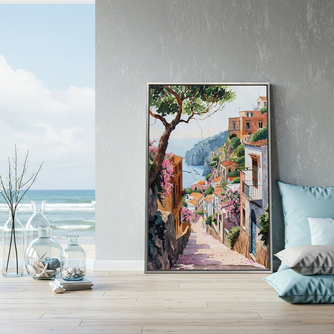 Framed Wall Art: Watercolor painting of Italian coastal town. Warm color palette with pink flowers, terracotta roofs, and blue sea. Perfect home decor.