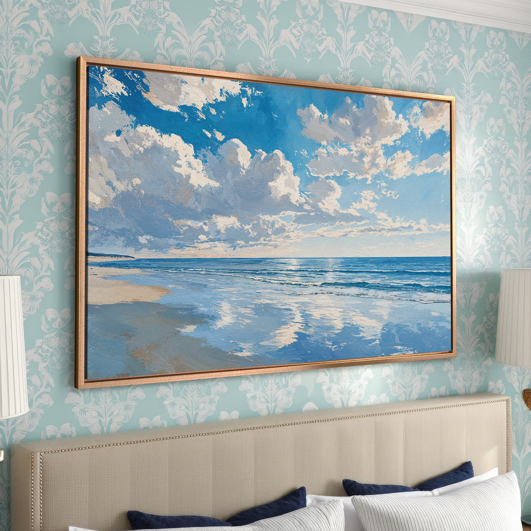 Framed Wall Art: Serene beach scene canvas print with blue sky, white clouds, and ocean in a calming blue and beige palette. Perfect for coastal decor.