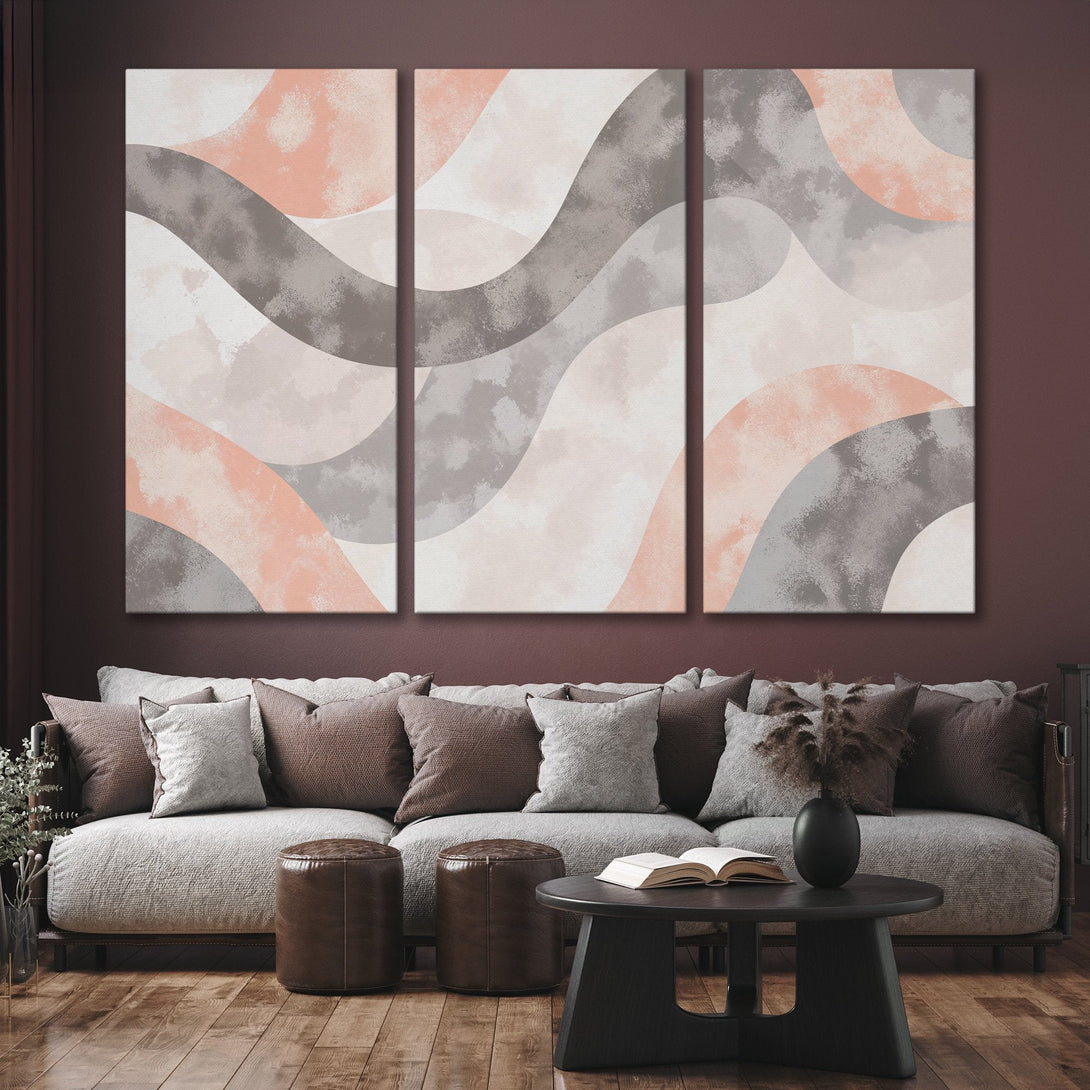 Abstract Canvas Print triptych in a modern interior. Features flowing shapes in a muted color palette of blush, gray, and white. Perfect for any room!
