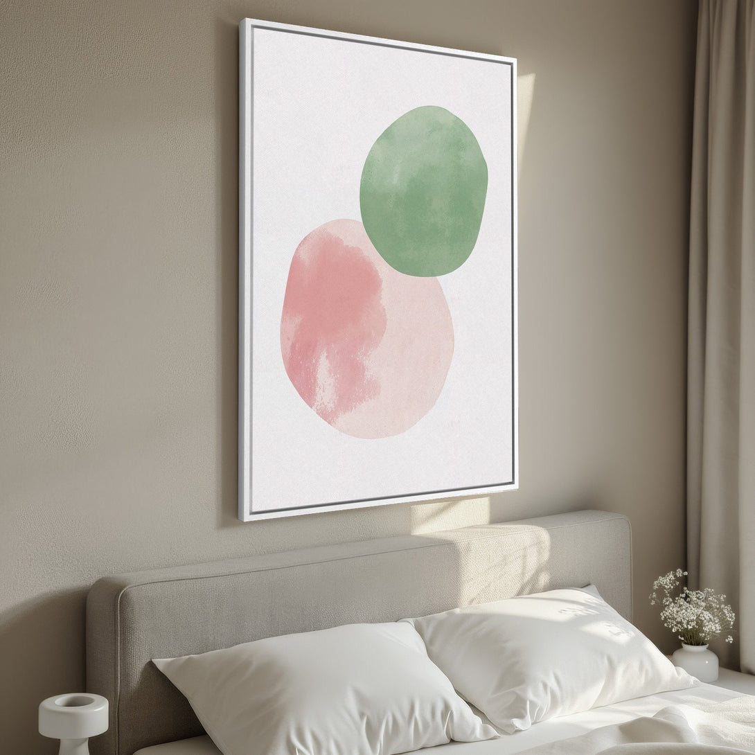 Framed Wall Art featuring abstract watercolor shapes in pink and green. Modern style canvas print with a neutral color palette, perfect for bedroom decor.