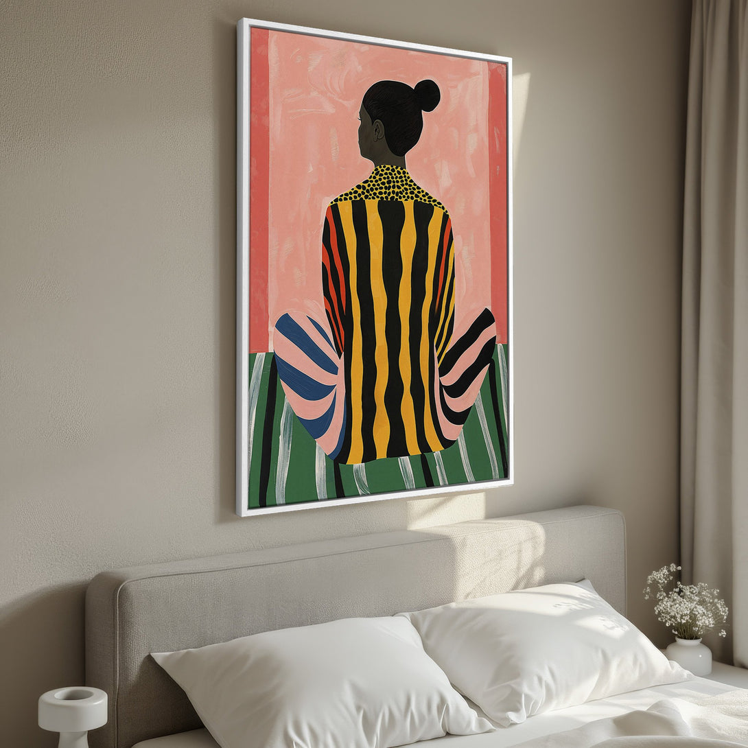 Framed Wall Art featuring a seated figure in bold, colorful stripes. Modern art with a warm, inviting color palette. Perfect for bedroom decor.