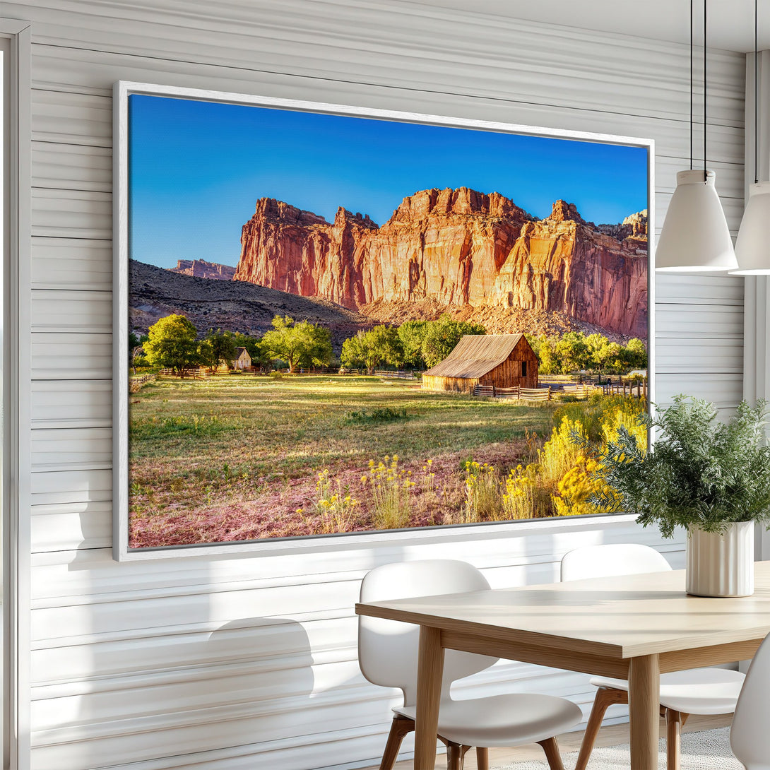 Framed Wall Art featuring a scenic landscape with a barn and mountains, warm earth tones, and a vibrant blue sky. Perfect for rustic decor.