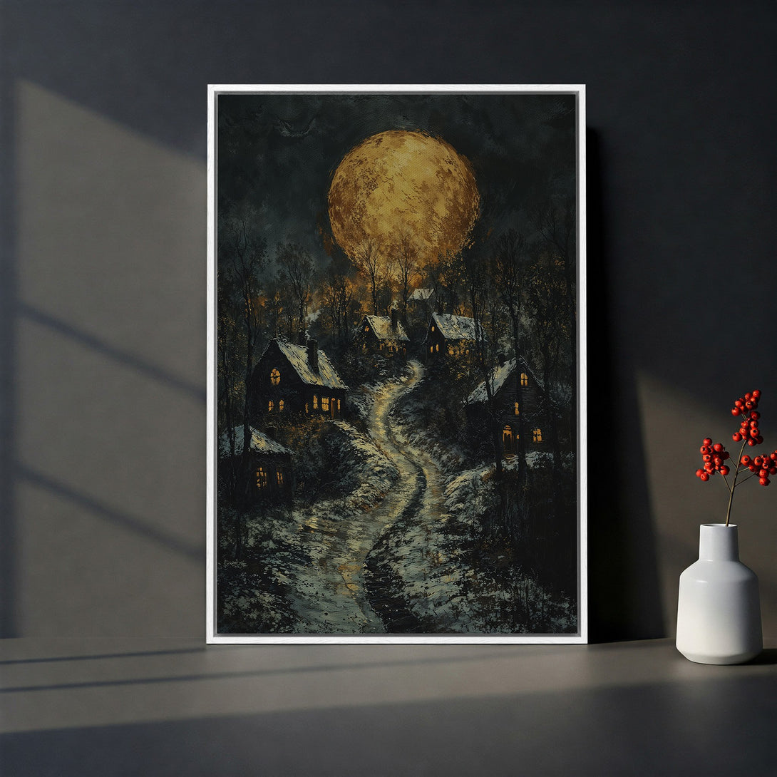 Framed Wall Art featuring a winter village scene under a golden moon. Dark, moody color palette with a touch of warmth. Perfect for adding a cozy aesthetic.