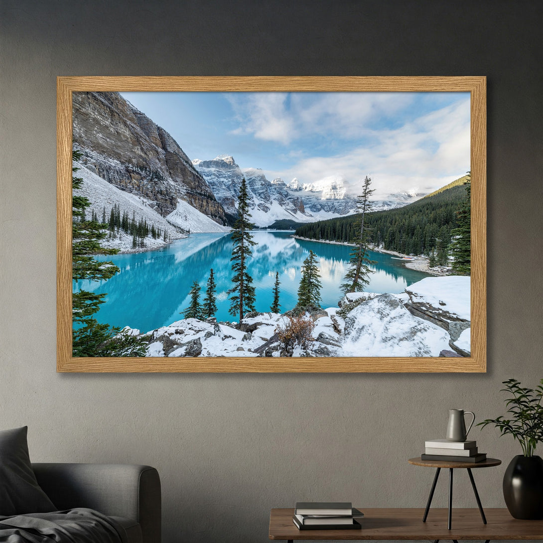 Framed Poster of a stunning mountain lake scene. Captivating landscape art with turquoise water, snowy peaks, and a natural wood frame.