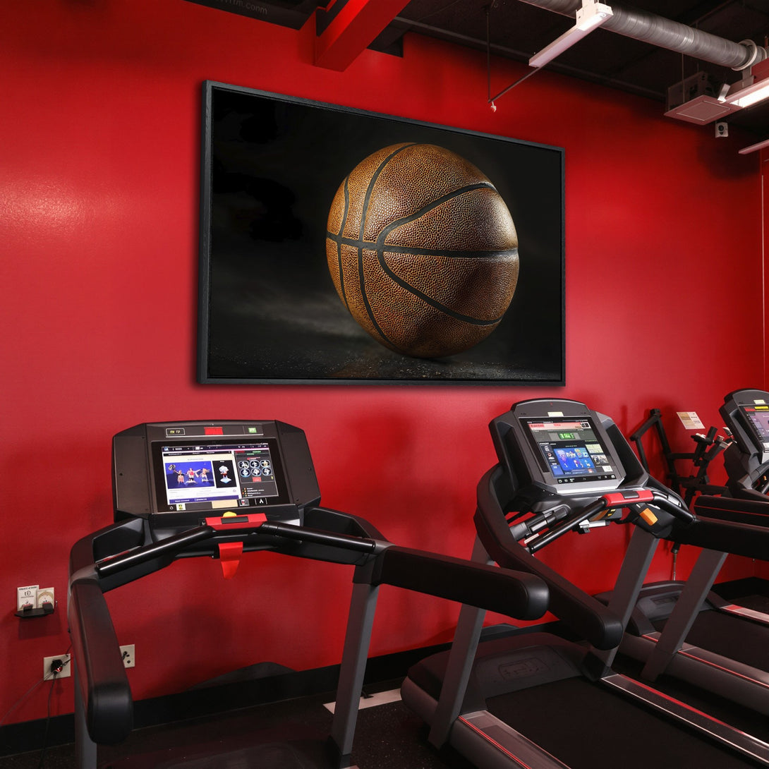 Framed Wall Art: Stunning basketball canvas print in a modern gym. Warm brown tones pop against a vibrant red wall, creating a bold statement piece.