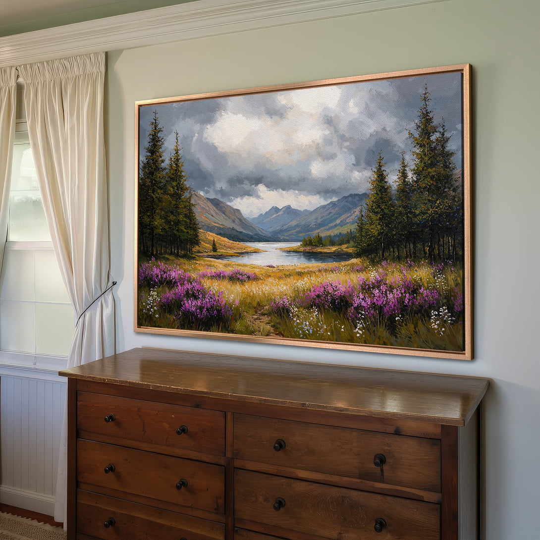 Framed Wall Art: Landscape Canvas Print with a mountain lake scene. Features a moody sky, green trees, and purple flowers. Earthy tones.