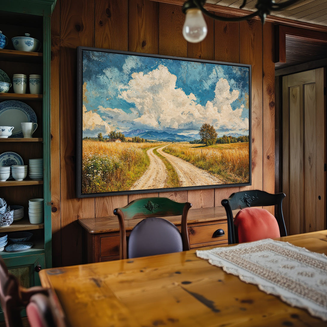 Framed Wall Art: Rustic landscape Canvas Print in a warm, inviting interior. Featuring a dirt road, blue sky, and golden fields. Perfect for farmhouse decor.