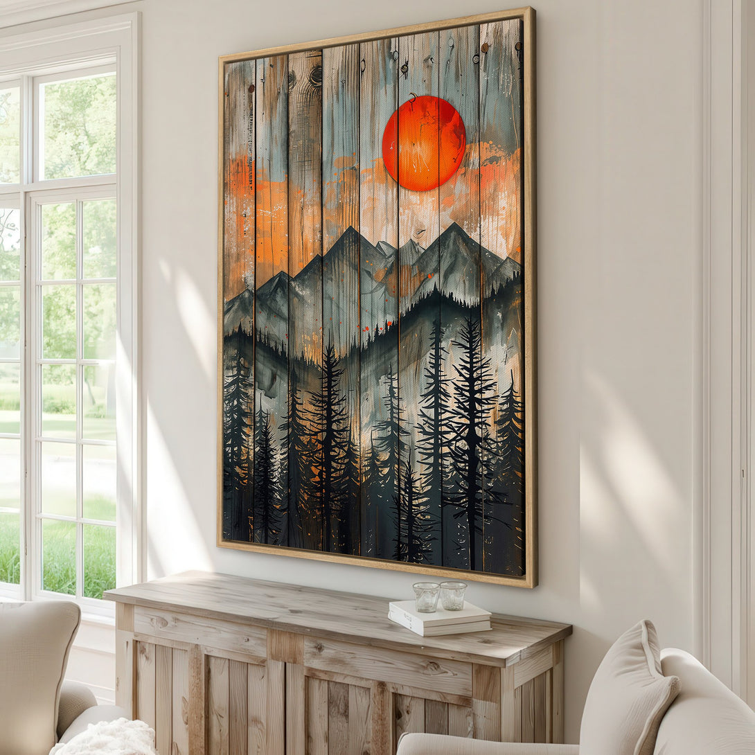 Framed Wall Art: Mountain landscape Canvas Print with a rustic, wood-grain background. Features a vibrant orange sun and a palette of black, gray, and orange hues. Perfect for modern decor.