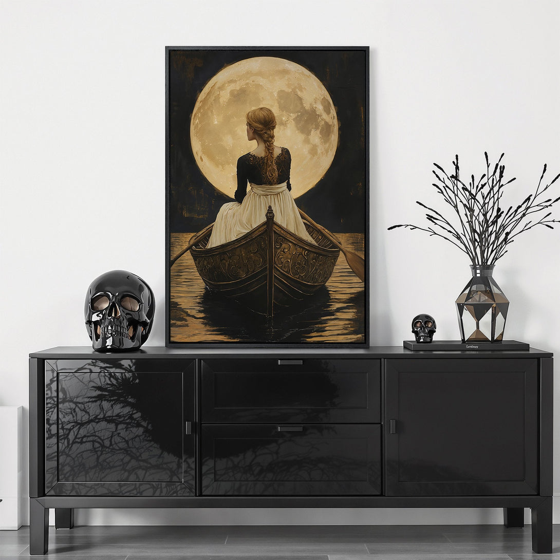 Framed Wall Art: Woman in boat under moon. Romantic, vintage style canvas print with a moody, gold and black color palette. Perfect for any room!