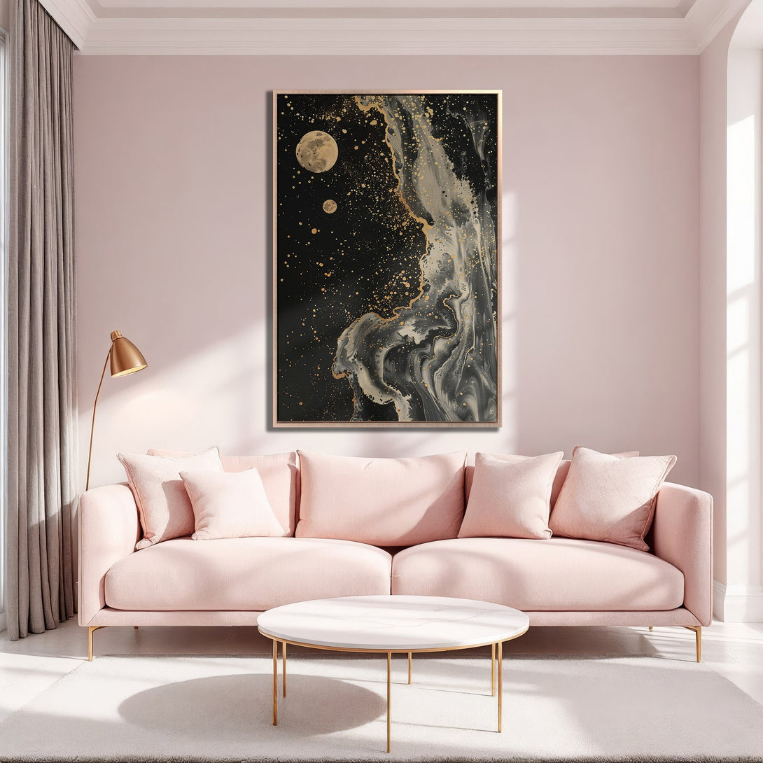 Framed Wall Art featuring an abstract black and gold design with a moon motif. Modern art print in a blush pink interior, perfect for living room decor.