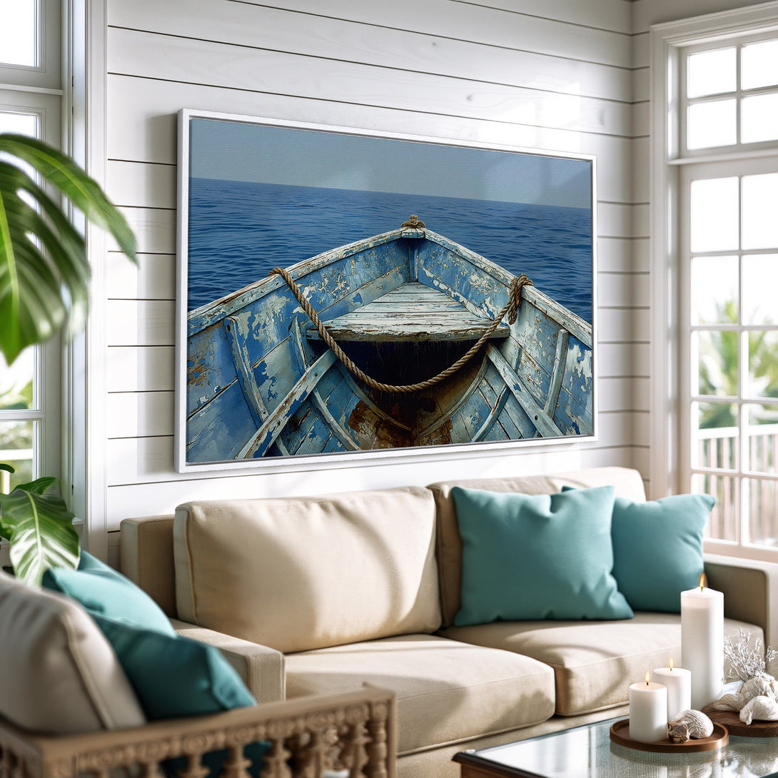 Framed Wall Art: Rustic boat at sea canvas print in a coastal living room. Blue, white, and neutral tones create a serene, nautical aesthetic.