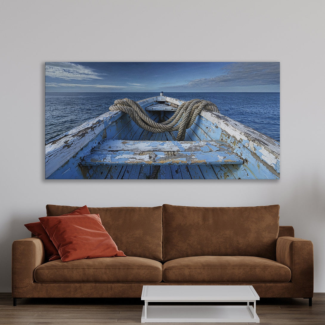 Framed Wall Art of a weathered blue boat on the sea. Coastal style art with a calming blue and neutral color palette, perfect for adding a touch of serenity.