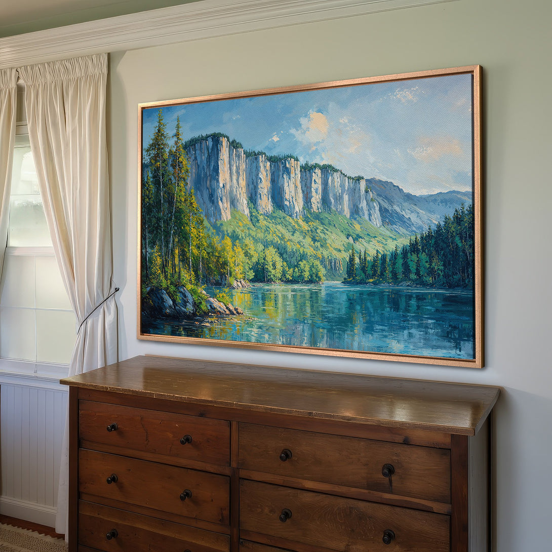 Framed Wall Art featuring a serene landscape painting with mountains, lake, and trees. Earthy tones and blue sky create a calming atmosphere. Perfect for home decor.