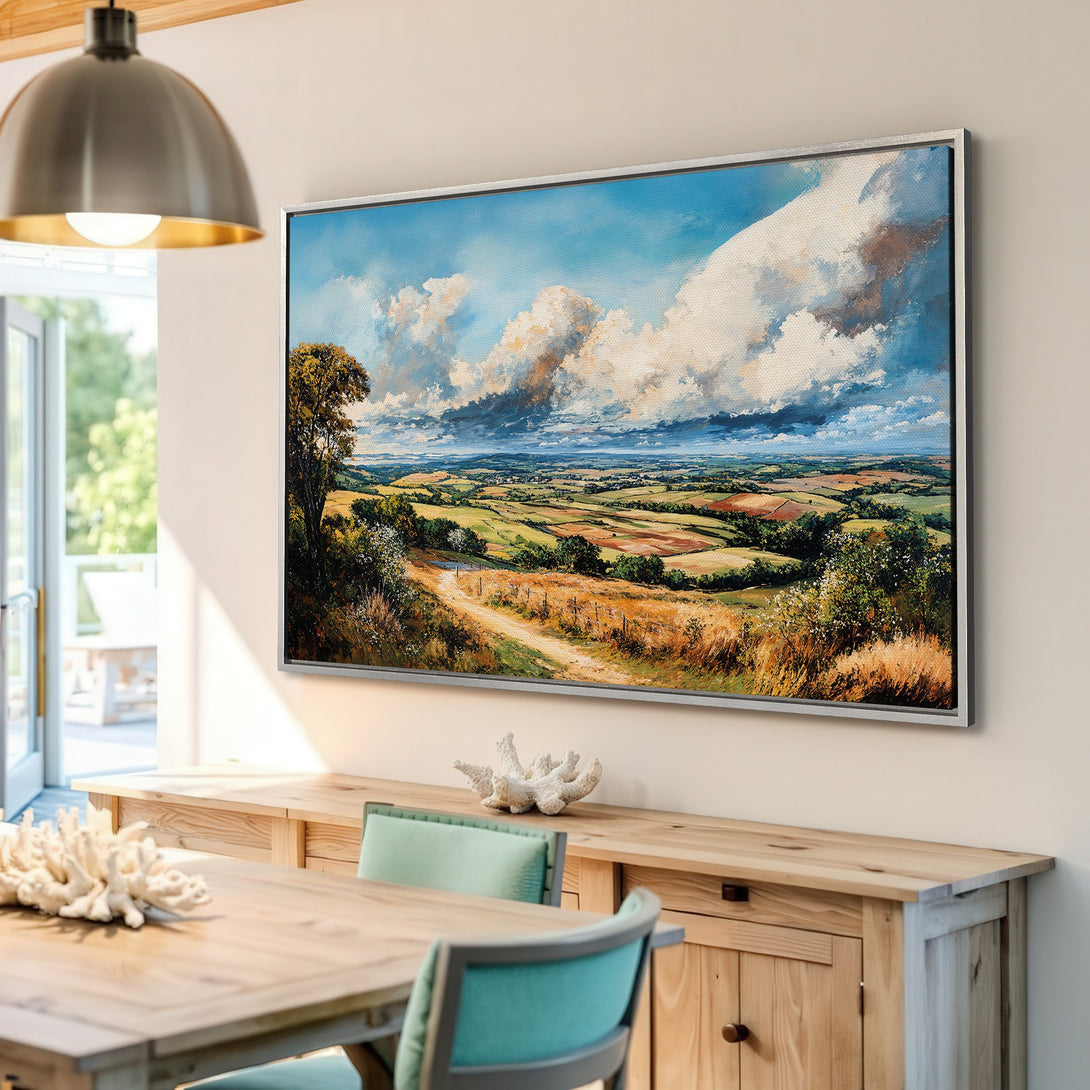 Framed Wall Art: Landscape Canvas Print in a bright interior. Features a vibrant countryside scene with blue skies, green fields, and warm, earthy tones.