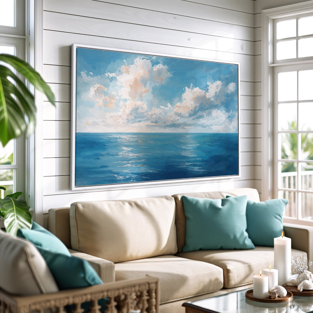 Framed Wall Art: Ocean scene canvas print in a coastal living room. Blue, white, and beige color palette. Perfect for adding a calming touch to your home.