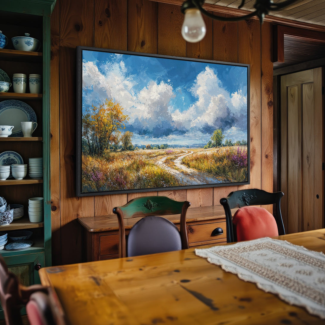 Framed Wall Art: Landscape painting with blue sky, clouds, and a path. Earthy tones complement the warm interior. Perfect for home decor.