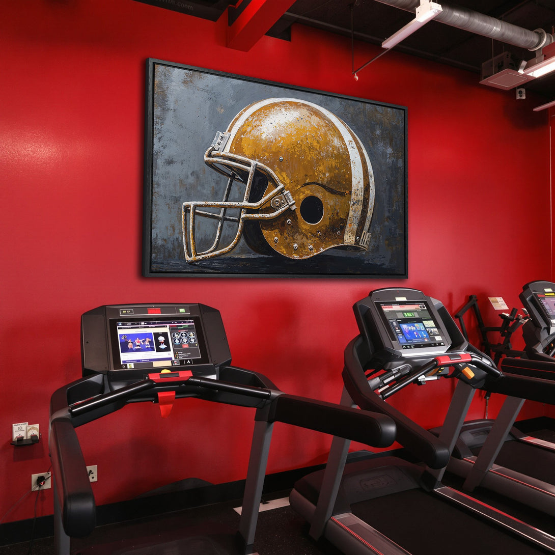 Framed Wall Art: Abstract football helmet art in gold and grey, displayed in a modern gym setting. Perfect for sports fans!