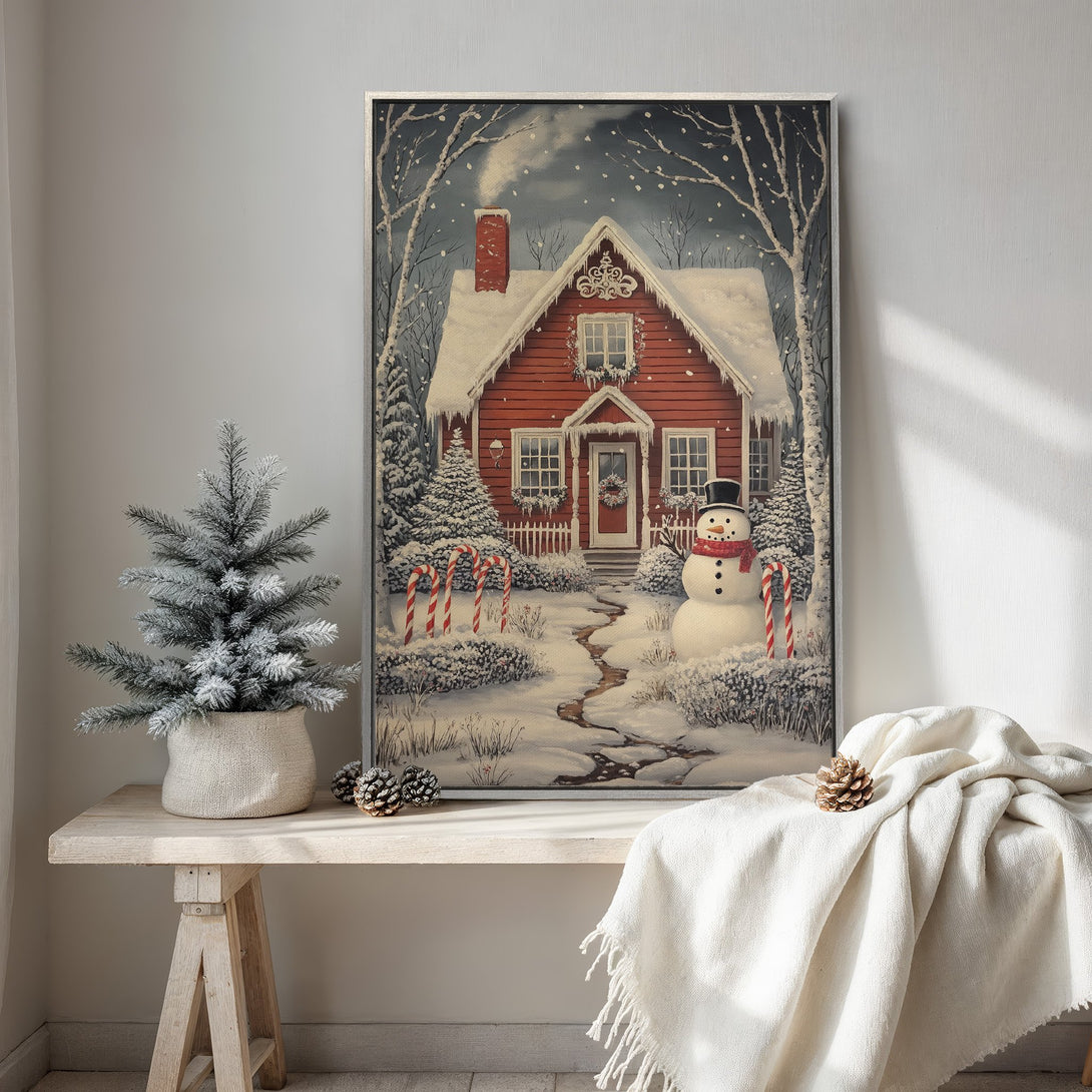 Framed Wall Art: Cozy winter scene Canvas Print featuring a red house, snowman, and snowy landscape. Warm, inviting color palette perfect for holiday decor.