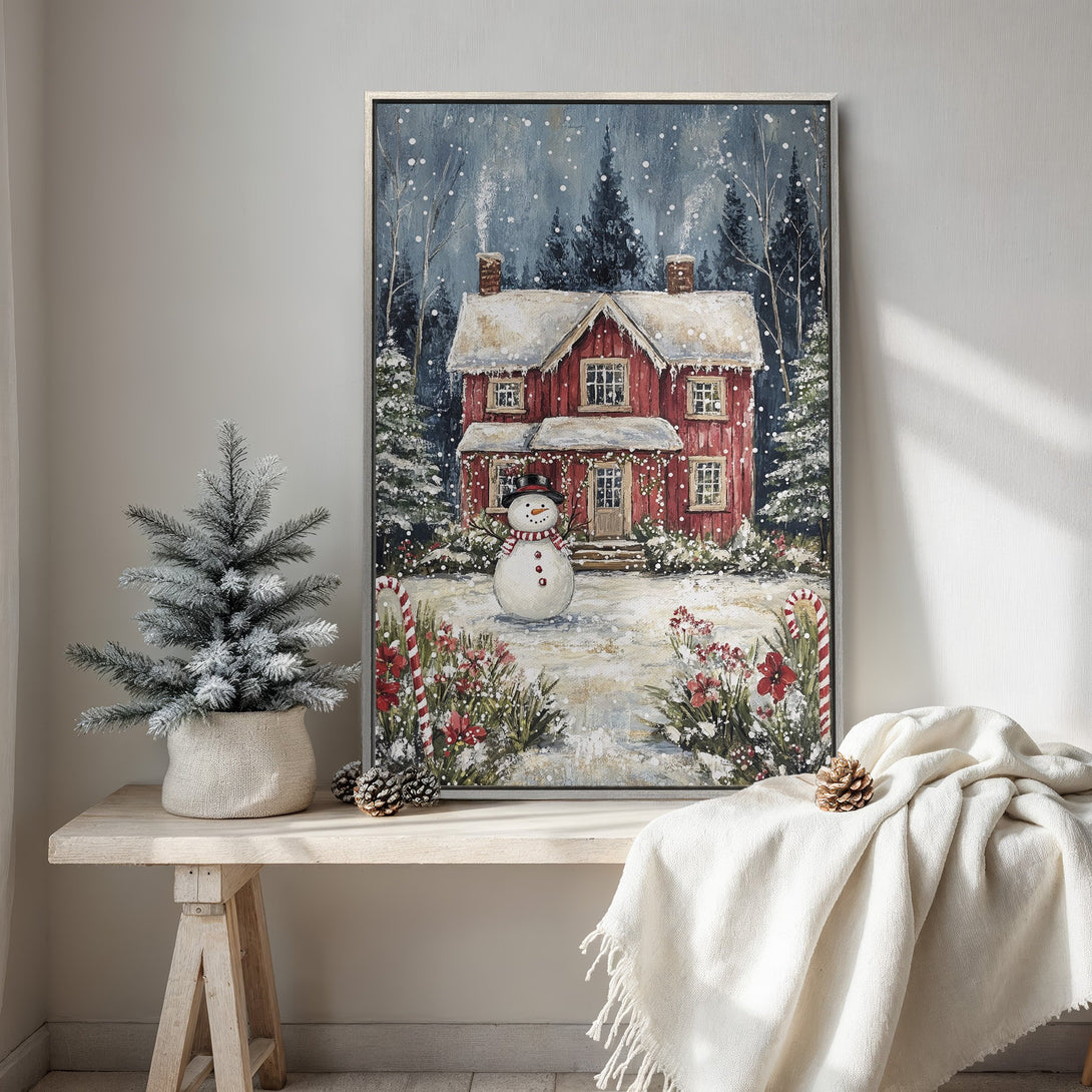 Framed Wall Art featuring a cozy winter scene with a red house and snowman. Warm, inviting color palette perfect for holiday decor. Add a touch of charm to your home!