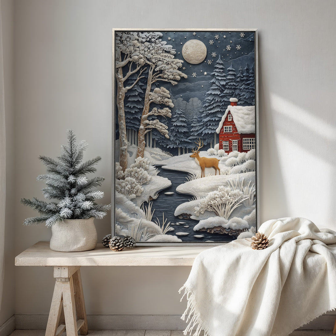 Framed Wall Art featuring a winter landscape with a red cabin and deer. Serene, textured style with blue, white, and red color palette. Perfect for cozy decor.