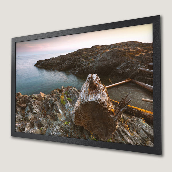 Framed Poster of coastal landscape with rocks, water, and sunset colors. Nature-inspired art print.