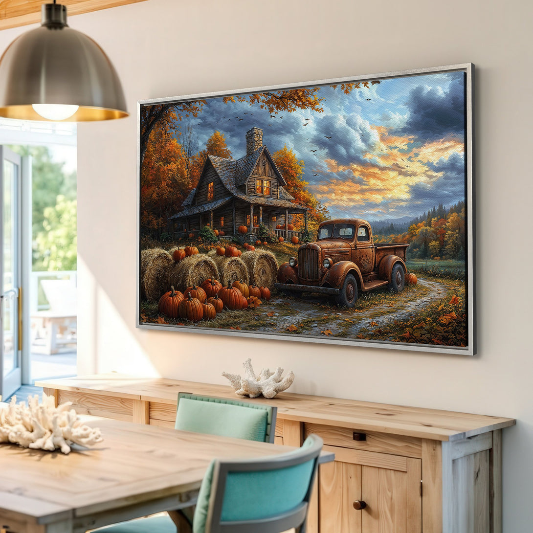 Framed Wall Art: Rustic autumn scene with a cabin, truck, and pumpkins. Warm orange, yellow, and blue color palette for cozy fall decor.