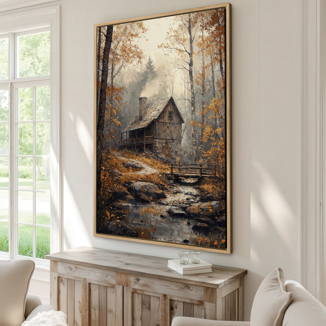 Framed Wall Art featuring a rustic cabin in a forest scene. Warm color palette of autumn golds, browns, and grays. Perfect for cozy home decor.