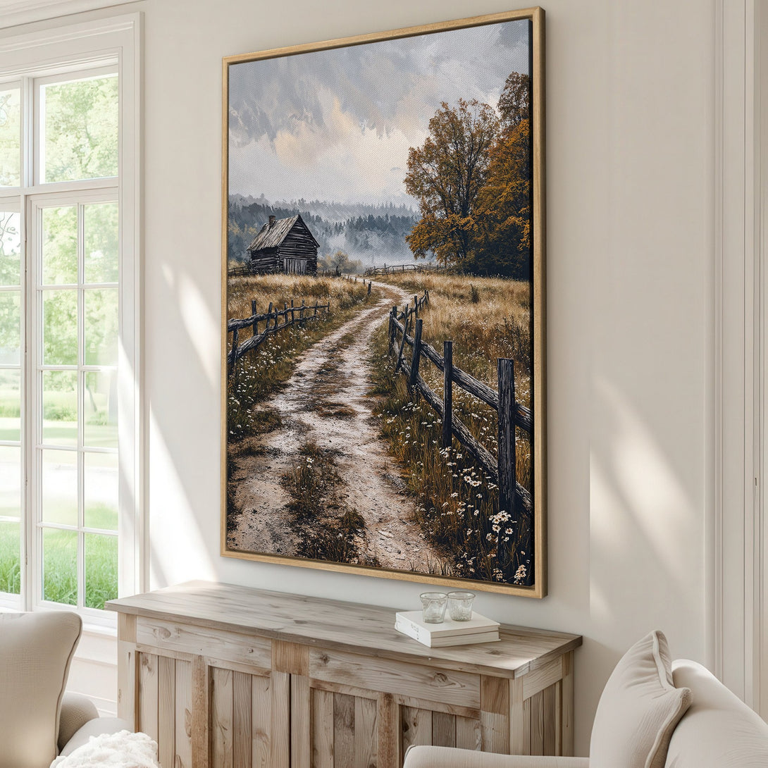 Framed Wall Art: Rustic landscape Canvas Print with a dirt road, cabin, and fall foliage. Earthy tones of brown, gold, and gray create a cozy, inviting atmosphere.