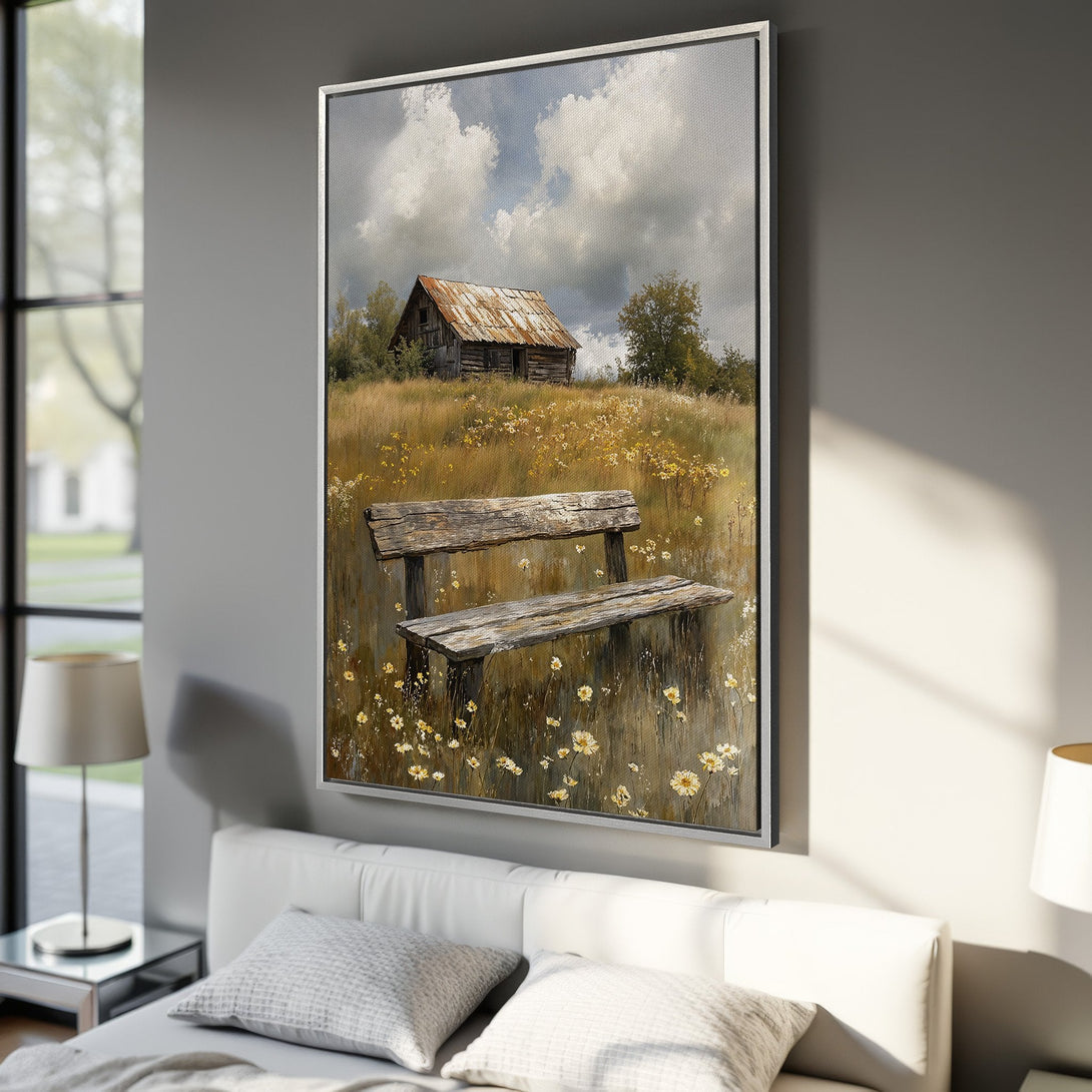 Framed Wall Art featuring a rustic landscape with a cabin, bench, and wildflowers. Earthy tones and a serene style create a calming atmosphere.
